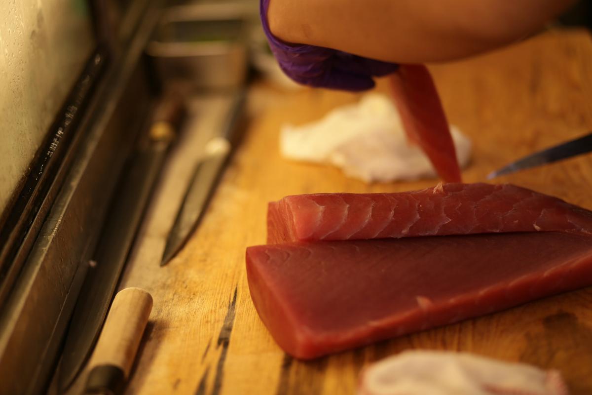 The chef slicing tuna with careful precision